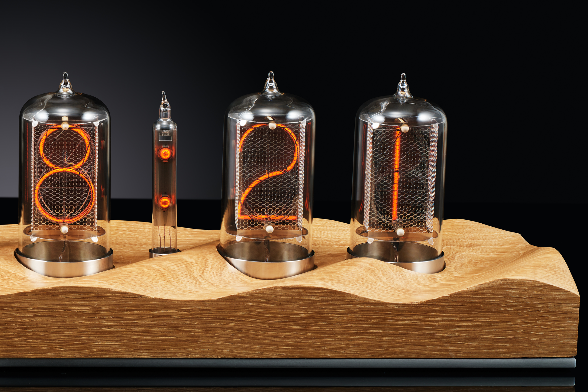 Close up of a nixie clock with a carved oak base